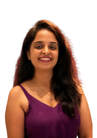 A smiling woman with long dark hair wearing a purple sleeveless top, photographed against a solid dark burgundy background.